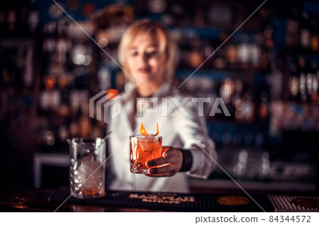 Girl barman formulates a cocktail in the taproom 84344572