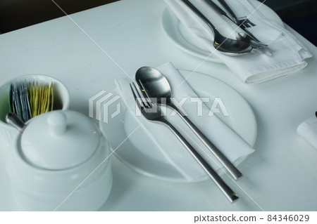 cutlery and empty plate on wooden background top down 84346029