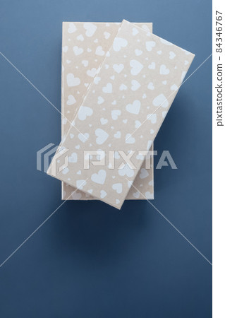 Two beige gift boxes with pattern of hearts on a blue background. Top view Two beige gift boxes with pattern of hearts on a blue background. Top view 84346767