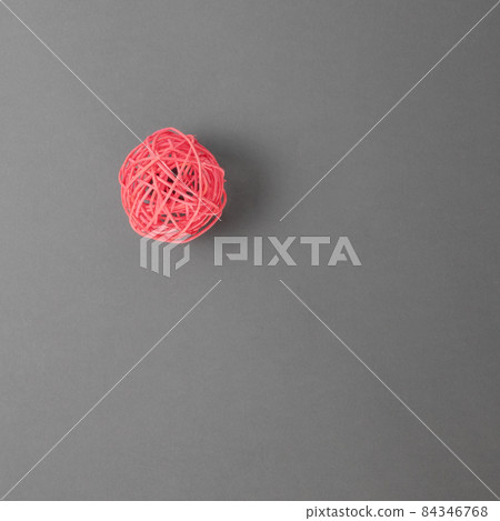 Red braided decorative ball on a gray background. Top view Red braided decorative ball on a gray background. Top view 84346768