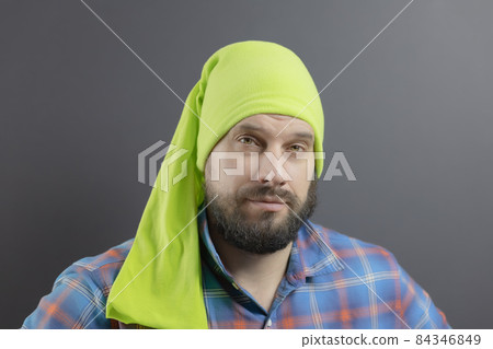 Bearded man in a light green long bandana on his head and a plaid blue shirt Bearded man in a light green long bandana on his head and a plaid blue shirt 84346849