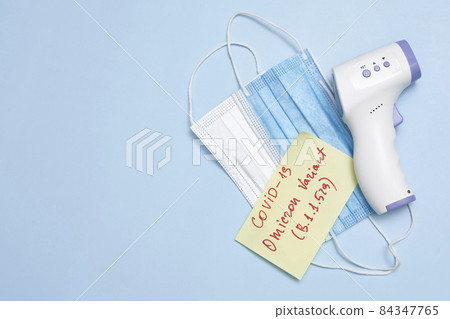 Omicron variant text on piece of paper. New covid variant from South Africa. Vaccine vial, syringe and face mask on bright colored background. New South African omicron variant of SARS-CoV-2 84347765