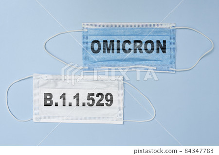 Female doctor holds a face mask with - Omicron variant text on it. Covid-19 new variant - Omicron. Omicron variant of coronavirus. SARS-CoV-2 variant of concern Female doctor holds a face mask with - Omicron variant text on it. Covid-19 new variant - Omicron. Omicron variant of coronavirus. SARS-CoV-2 variant of concern 84347783