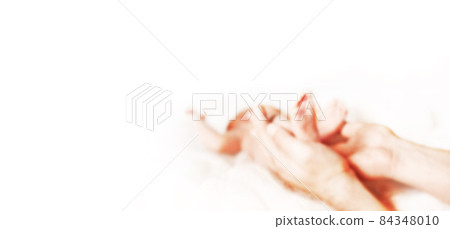 mom holds the legs of her newborn baby. blurred image for the advertising text. mom holds the legs of her newborn baby. blurred image for the advertising text. 84348010