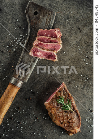 Grilled beef steak fillet with ingredients and herbs on black board, product image for restaurant 84349345