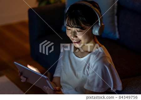 Young woman relaxing in the room at night 84349756