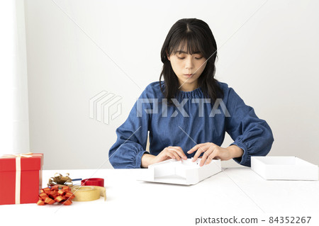 一位女士在辦公桌前組裝禮盒 一位女士在辦公桌前組裝禮盒 84352267