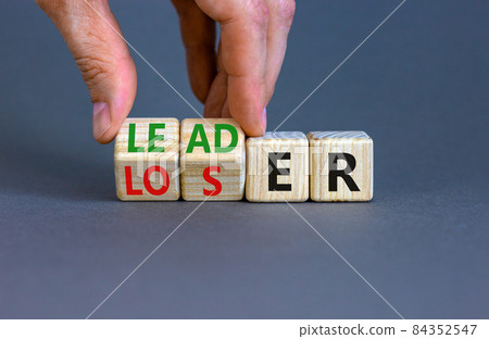 Loser or leader symbol. Businessman turns cubes and changes the word 'loser' to 'leader'. Beautiful grey table, grey background. Business and loser or leader concept. Copy space. Loser or leader symbol. Businessman turns cubes and changes the word 'loser' to 'leader'. Beautiful grey table, grey background. Business and loser or leader concept. Copy space. 84352547