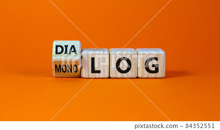 Fliped a cube and changed the German word 'monolog' - 'monologue' in English to 'dialog' - 'dialogue' in English. Beautiful orange background. Business concept. Copy space. Fliped a cube and changed the German word 'monolog' - 'monologue' in English to 'dialog' - 'dialogue' in English. Beautiful orange background. Business concept. Copy space. 84352551