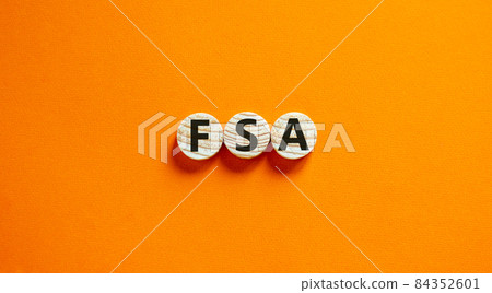 Concept words 'FSA, flexible spending account' on wooden circles on a beautiful orange background. Copy space, business concept. Concept words 'FSA, flexible spending account' on wooden circles on a beautiful orange background. Copy space, business concept. 84352601