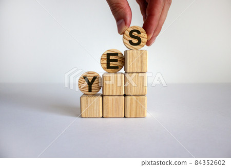 Business concept growth success process. Male hand. Wood blocks and circles with word 'yes' stacking as step stair on white background, copy space. Business concept growth success process. Male hand. Wood blocks and circles with word 'yes' stacking as step stair on white background, copy space. 84352602