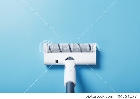 White vacuum cleaner brush on a blue background, top view. Cleaning concept White vacuum cleaner brush on a blue background, top view. Cleaning concept 84354158