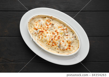 Overhead view of potato and hamboletus baked in oven with cheese and bacon 84354263