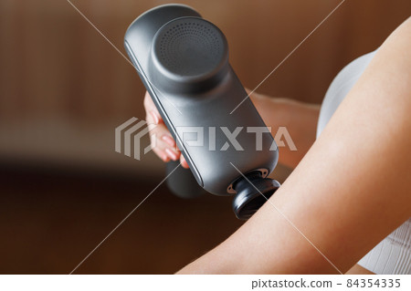 Self-massage of women's hands using a percussion gun at home. Self-massage of women's hands using a percussion gun at home. 84354335