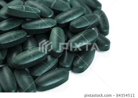 Pills with Vitamins and spirulina on a white background. Pills with Vitamins and spirulina on a white background. 84354511