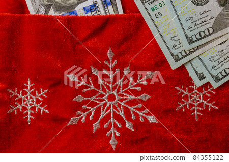 Christmas decoration Santa red bag US dollar bills on red background Christmas decoration Santa red bag US dollar bills on red background 84355122