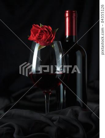Bottle and glass of red wine with red rose. Bottle and glass of red wine with red rose. 84355126