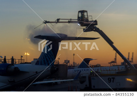 Flight safety with airport staff preparing airplane for the flight deicing the wing of the aircraft at winter from outside the airplane Flight safety with airport staff preparing airplane for the flight deicing the wing of the aircraft at winter from outside the airplane 84355130