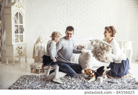 happy family and pet dog playing with pillows in spacious living room happy family and pet dog playing with pillows in spacious living room 84356025