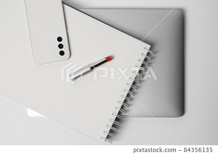 Minimalist and clean Female workspace with laptop, smart phone , notebook, and red lipstick 84356135