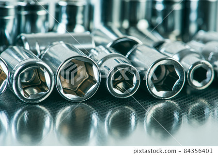 Set of socket wrenches on mettalic work shop table 84356401