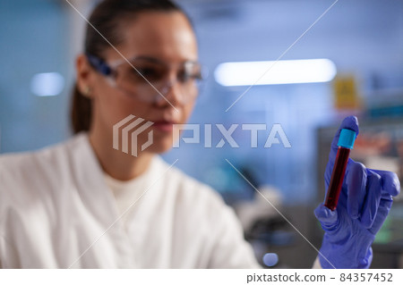 Specialist doctor holding medical test tube with blood sample analyzing dna expertise 84357452