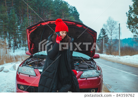 woman calling for help with broken down car at winter highway woman calling for help with broken down car at winter highway 84359762