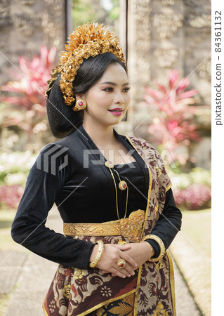 Beautiful woman wearing traditional Balinese clothes standing 84361132