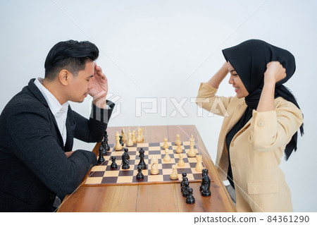 Veiled woman wins against man in suit while playing chess Veiled woman wins against man in suit while playing chess 84361290