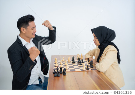 man in suit facing woman with veil while playing chess man in suit facing woman with veil while playing chess 84361336
