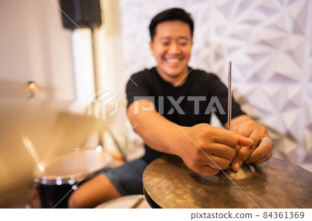 selective focus of a drummer's hand setting up hi-hat clutch cymbals before use selective focus of a drummer's hand setting up hi-hat clutch cymbals before use 84361369