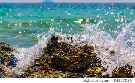 Waves hitting round rocks and splashing Waves hitting round rocks and splashing 84367026