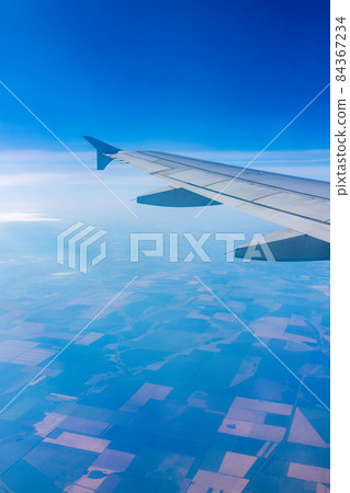 View from the airplane window at a beautiful blee clear sky and the airplane wing View from the airplane window at a beautiful blee clear sky and the airplane wing 84367234