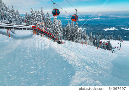 Ski gondolas over the ski slopes in Poiana Brasov, Romania 84367697