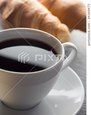 Cup of coffe and croissants 84369473