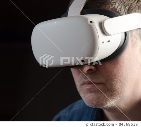 Man wearing a virtual reality headset Man wearing a virtual reality headset 84369619