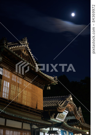 Dogo Onsen Main Building illuminated by the moonlit night. It is a tourist attraction in Matsuyama City, Ehime Prefecture, and is designated as an important cultural property. Dogo Onsen Main Building illuminated by the moonlit night. It is a tourist attraction in Matsuyama City, Ehime Prefecture, and is designated as an important cultural property. 84369972