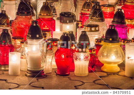 Burning grave candles in the cemetery at night. Burning grave candles in the cemetery at night. 84370951