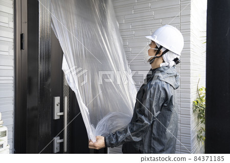 A painter who cures the entrance of a detached house 84371185