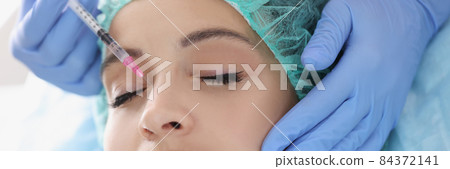 Doctor cosmetologist making injection in nasal area of woman patient in clinic 84372141