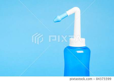 blue water pulse nasal wash bottle on a blue background, nasal irrigation concept blue water pulse nasal wash bottle on a blue background, nasal irrigation concept 84373399