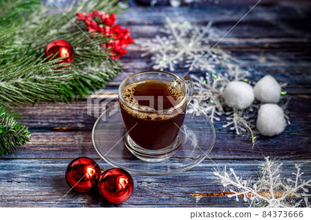 A cup of aromatic coffee with brown sugar, Christmas decorations, branches of a Christmas tree. Holiday concept New Year. On a wooden background. A cup of aromatic coffee with brown sugar, Christmas decorations, branches of a Christmas tree. Holiday concept New Year. On a wooden background. 84373666