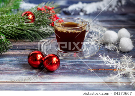 A cup of aromatic coffee with brown sugar, Christmas decorations, branches of a Christmas tree. Holiday concept New Year. On a wooden background. 84373667