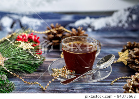 A cup of aromatic coffee with brown sugar, Christmas decorations, branches of a Christmas tree. Holiday concept New Year. On a wooden background. 84373668
