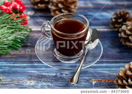 A cup of aromatic coffee with brown sugar, Christmas decorations, branches of a Christmas tree. Holiday concept New Year. On a wooden background. A cup of aromatic coffee with brown sugar, Christmas decorations, branches of a Christmas tree. Holiday concept New Year. On a wooden background. 84373669