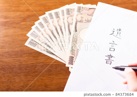 在信封和遺產賬單/錢上寫遺囑的手 84373684