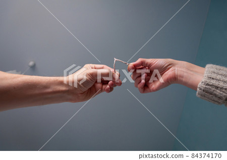Lucky wishbone from a chicken. Chance to make a wish. Pulling on a wishbone Lucky wishbone from a chicken. Chance to make a wish. Pulling on a wishbone 84374170
