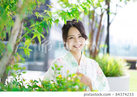 一個穿著浴衣走在城市裡的年輕女人 84374233