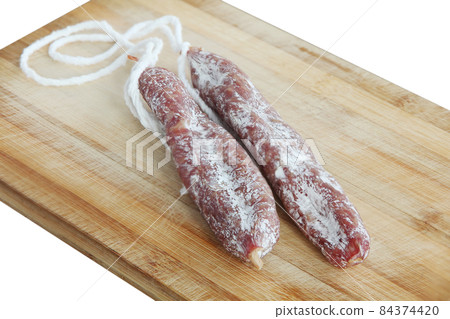 Mature air dried Spanish traditional sausage Fuet on wooden board. Mature air dried Spanish traditional sausage Fuet on wooden board. 84374420