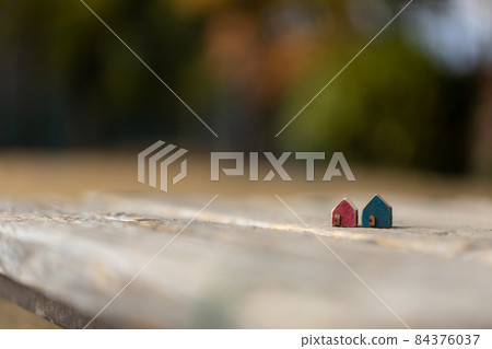 Two cute little wooden houses (autumn colored tree background) Two cute little wooden houses (autumn colored tree background) 84376037